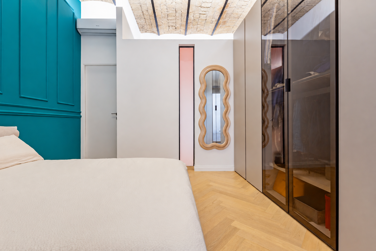 Camera da letto con parete blu petrolio e armadio in vetro