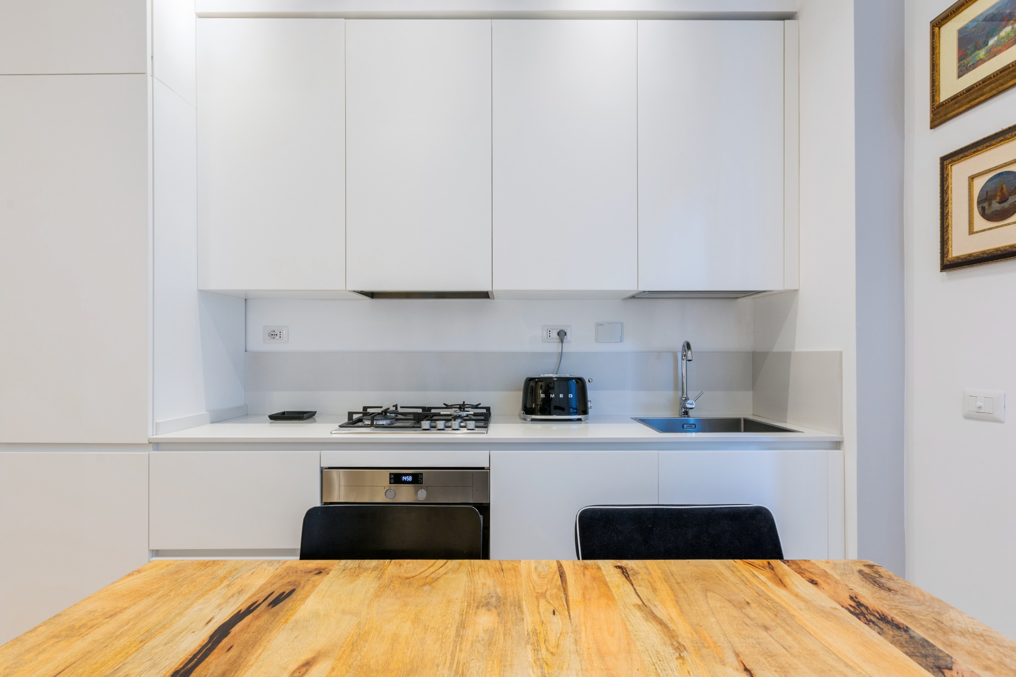 Cucina bianca compatta e tavolo in legno